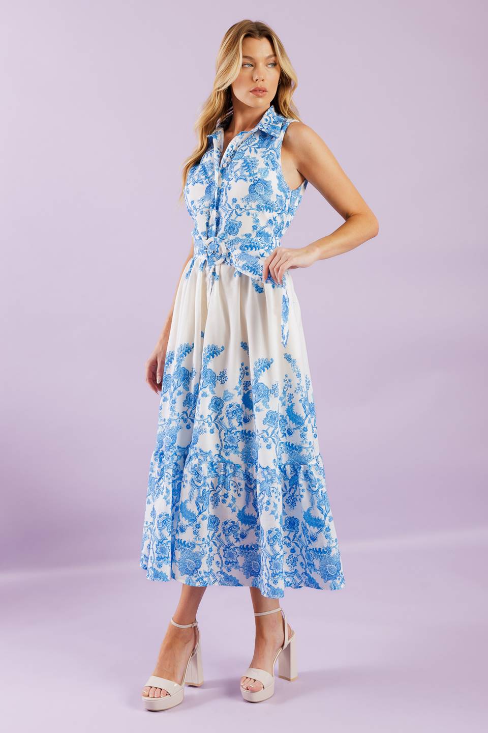 Elevate your vacation style with our Palm Shores Woven Midi Dress. This printed dress features a shirt collar, sleeveless design, and a flattering button-down front. The self belt cinches in your waist, while the full skirt with a ruffled hemline adds a touch of femininity.