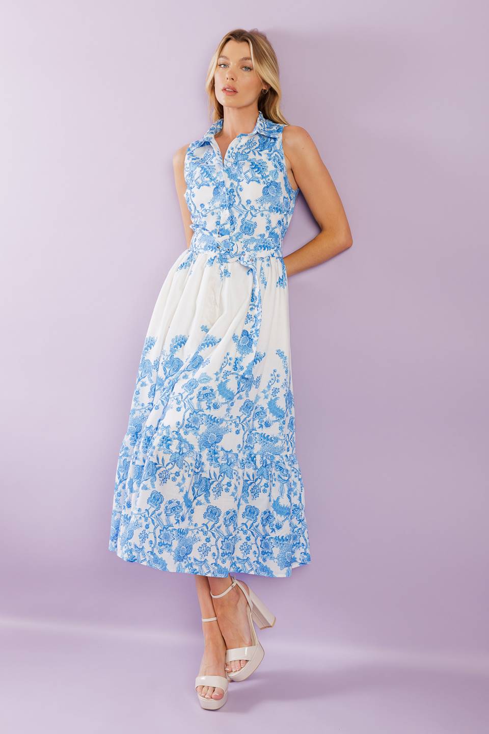 Elevate your vacation style with our Palm Shores Woven Midi Dress. This printed dress features a shirt collar, sleeveless design, and a flattering button-down front. The self belt cinches in your waist, while the full skirt with a ruffled hemline adds a touch of femininity.