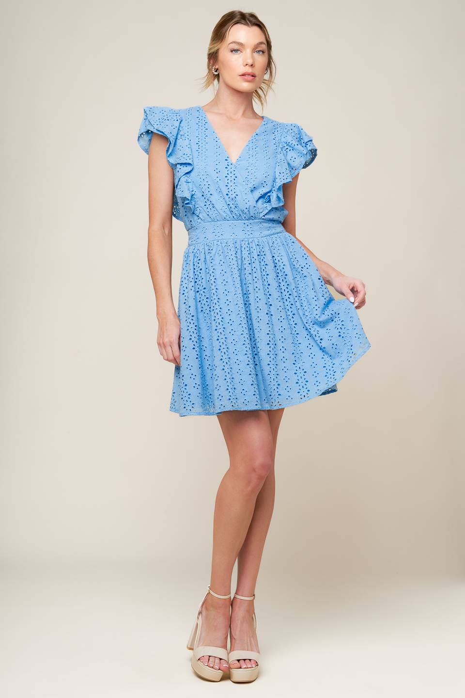 A powder blue woven eyelet mini dress featuring surplice neckline, ruffled sleeve, full skirt and smocked back waistband.