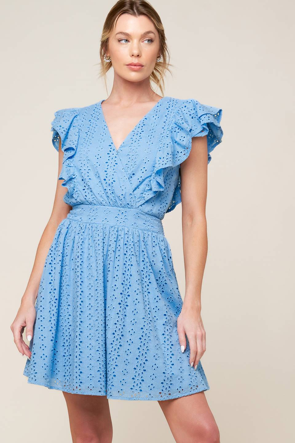 A powder blue woven eyelet mini dress featuring surplice neckline, ruffled sleeve, full skirt and smocked back waistband.