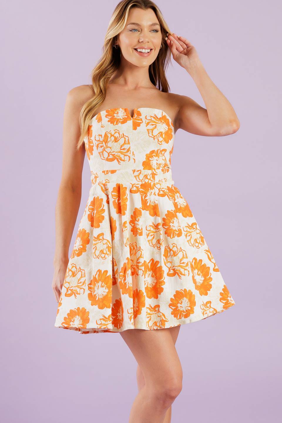 A white and orange printed woven mini dress featuring strapless neckline, full skirt and back zipper closure.