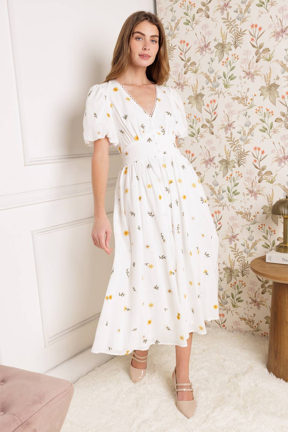 Indulge in the luxurious elegance of our embroidered midi dress, adorned with delicate lace detailing along the V neckline. With a button down bodice and short puff sleeves, this dress exudes sophistication. A waist yoke and full skirt add a touch of artful grace, while the smocked back waistband ensures a perfect fit.