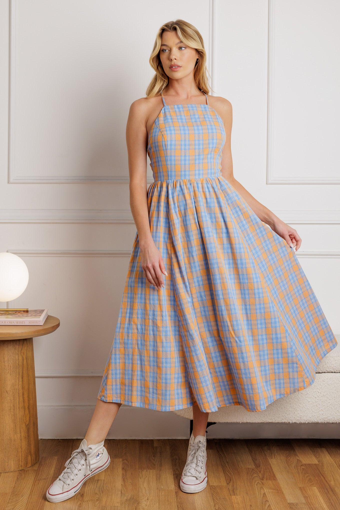 A printed woven midi dress featuring a straight neckline, full skirt, bareback with criss-cross strap and zipper closure