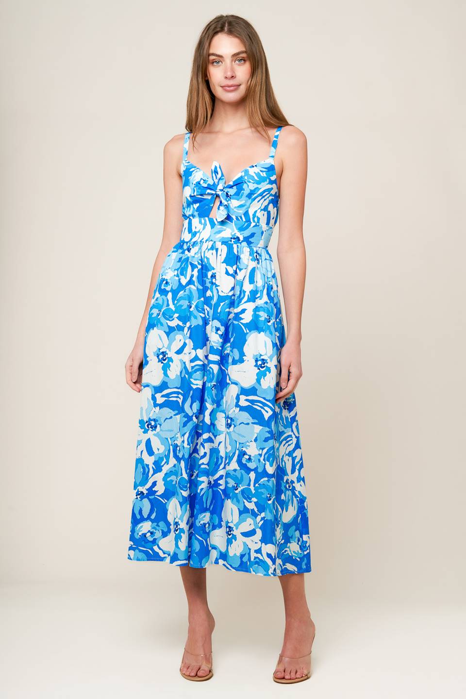 A blue and white printed woven midi dress featuring cami bodice with center front tie and cut out, wide waistband, full skirt and smocked back waistband.