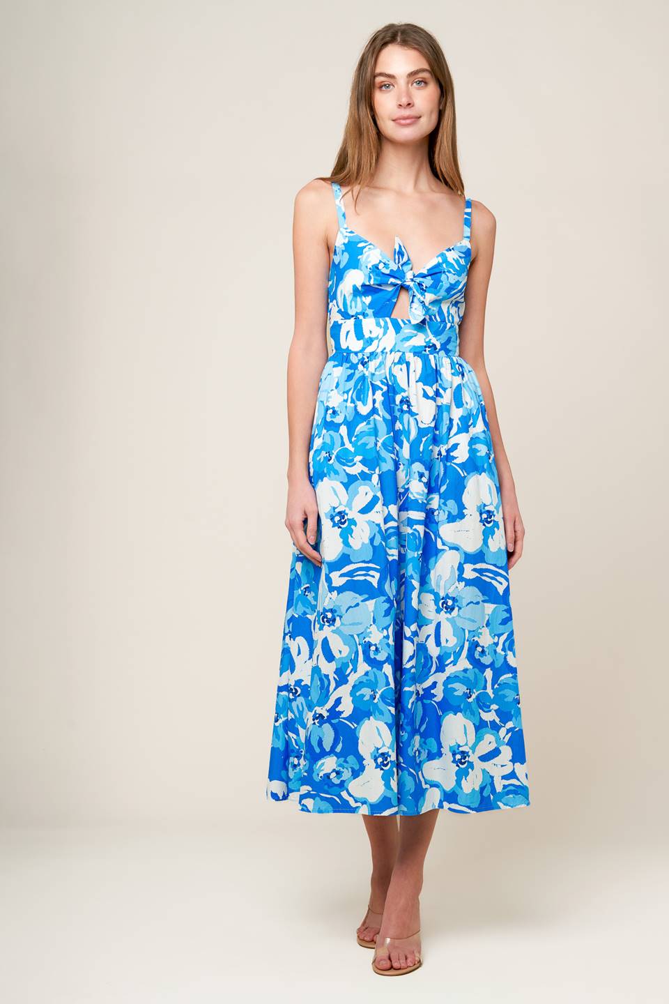 A blue and white printed woven midi dress featuring cami bodice with center front tie and cut out, wide waistband, full skirt and smocked back waistband.