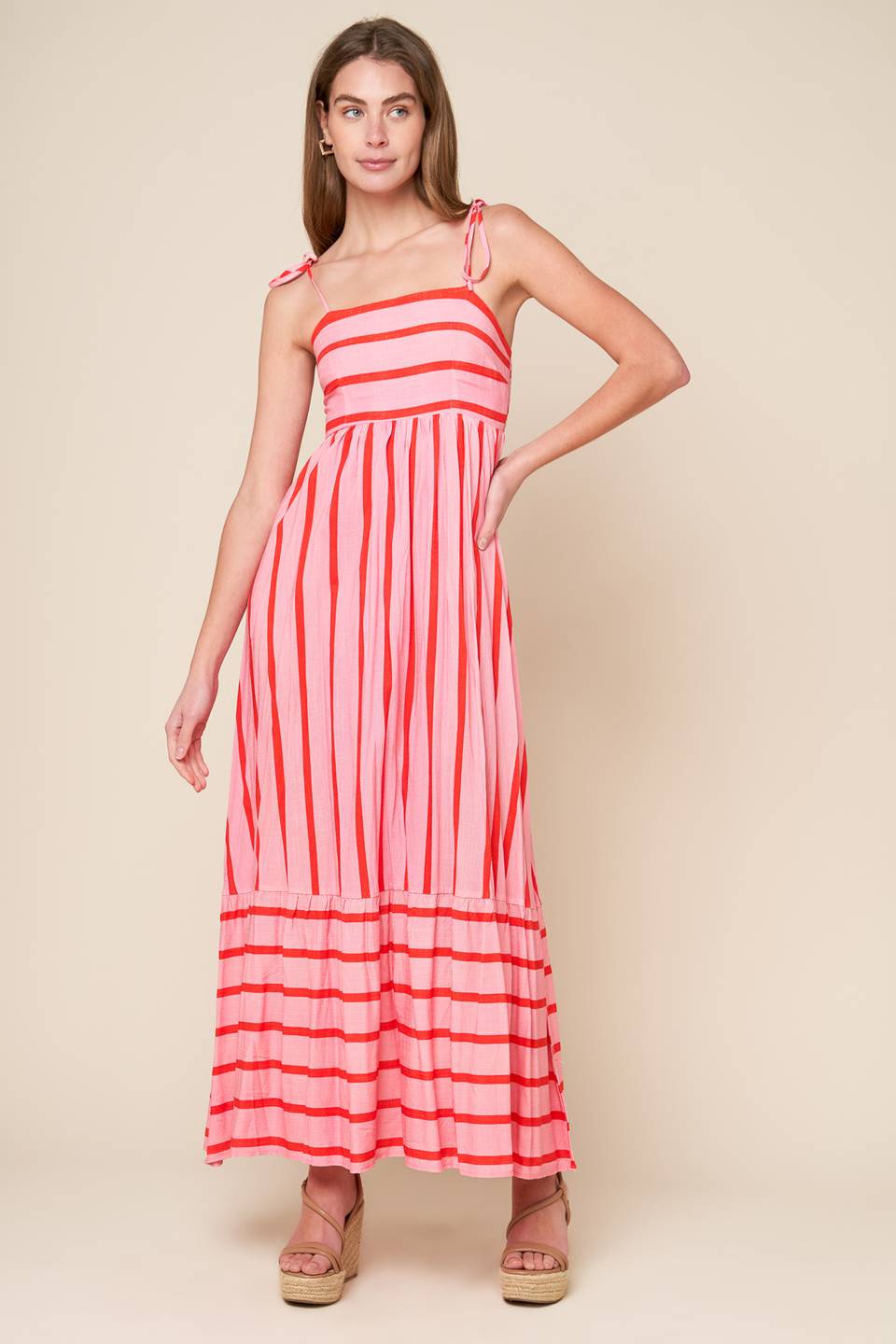 A pink and red striped woven midi dress featuring straight neckline, straps, ruffled hemline and smocked back bodice.