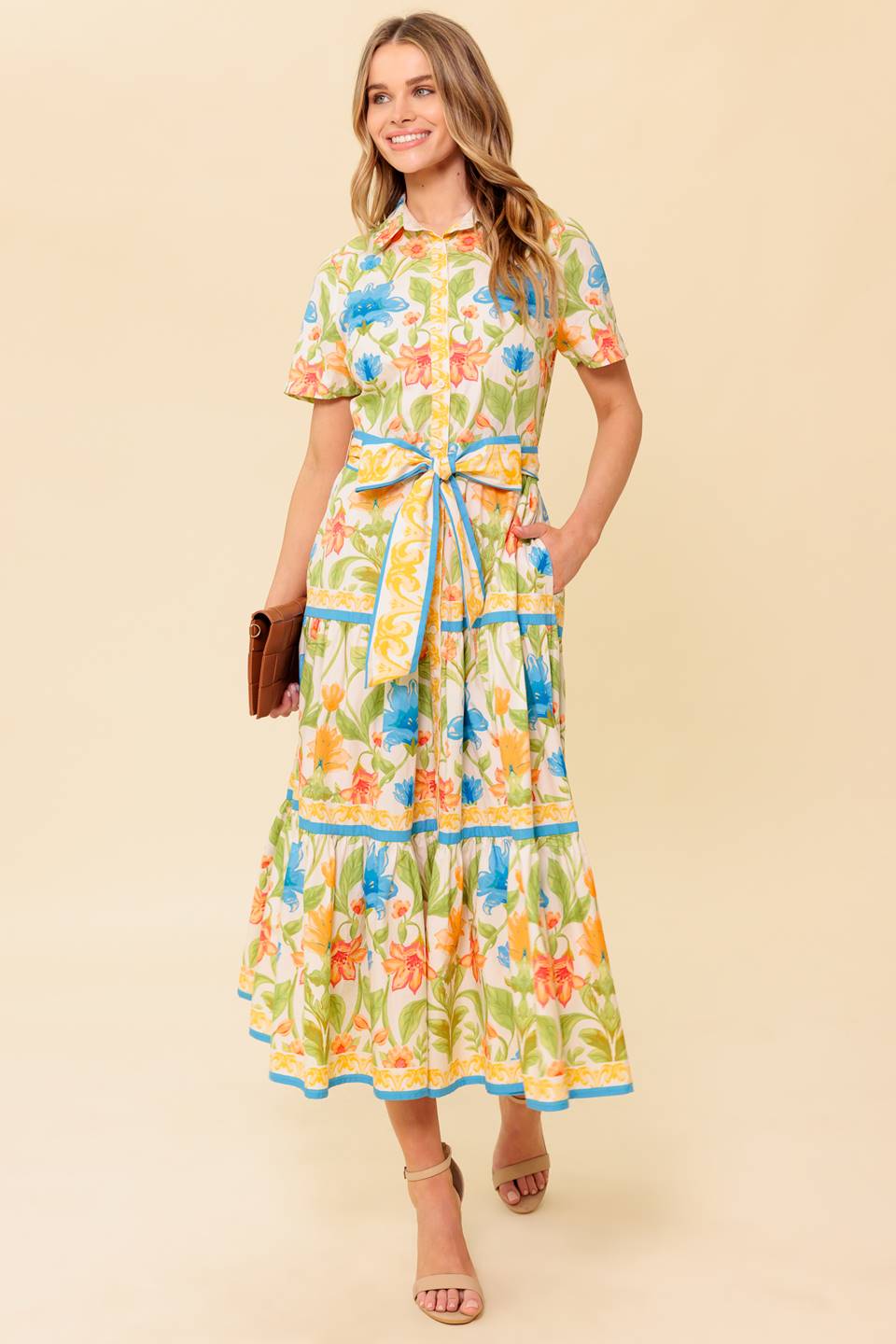 A printed woven midi dress featuring shirt collar, short sleeve, button down, self sash tie and tiered skirt