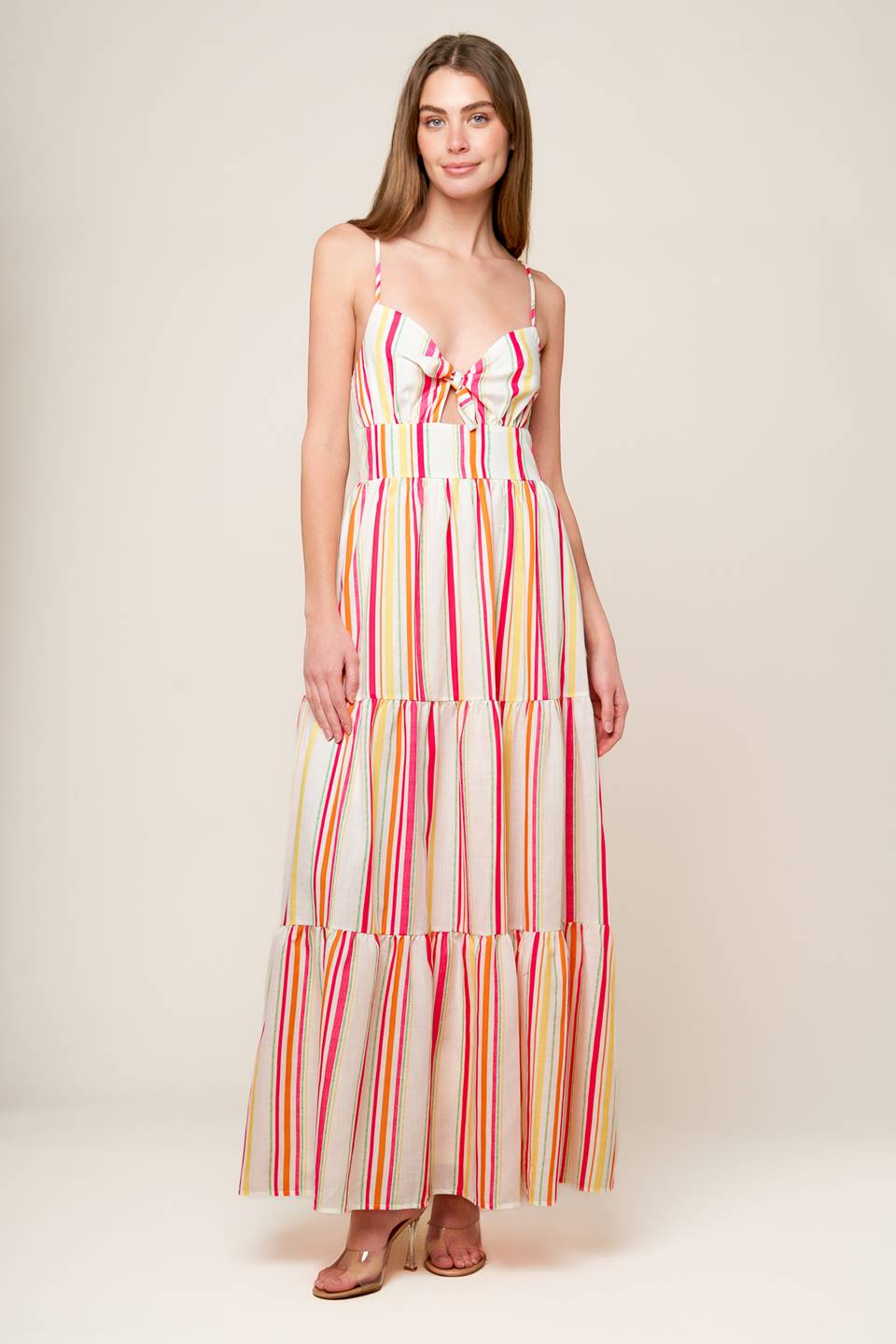 A striped woven maxi dress featuring cami bodice with center front tie and cut out, wide waistband, tiered skirt and smocked back bodice.