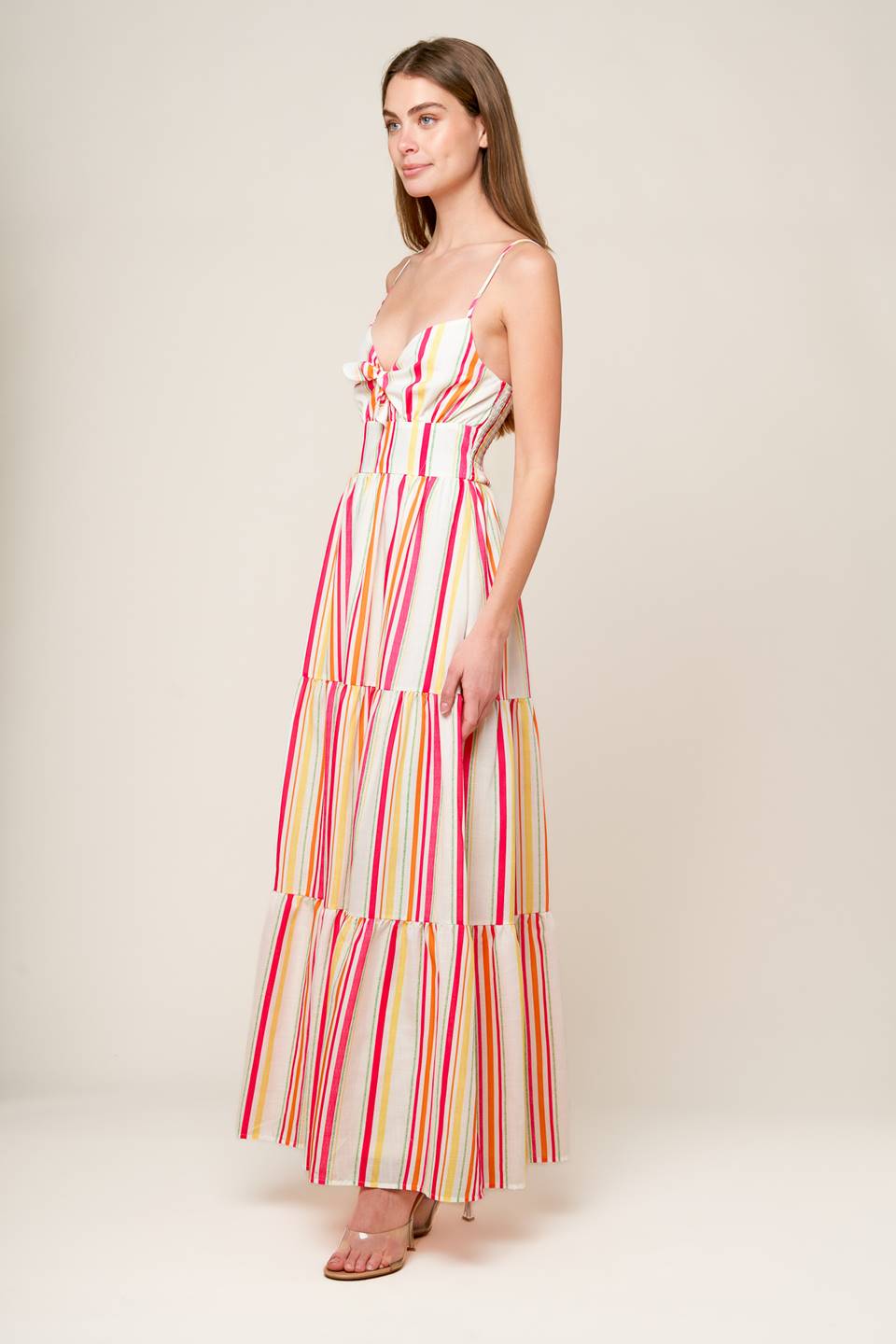 A striped woven maxi dress featuring cami bodice with center front tie and cut out, wide waistband, tiered skirt and smocked back bodice.