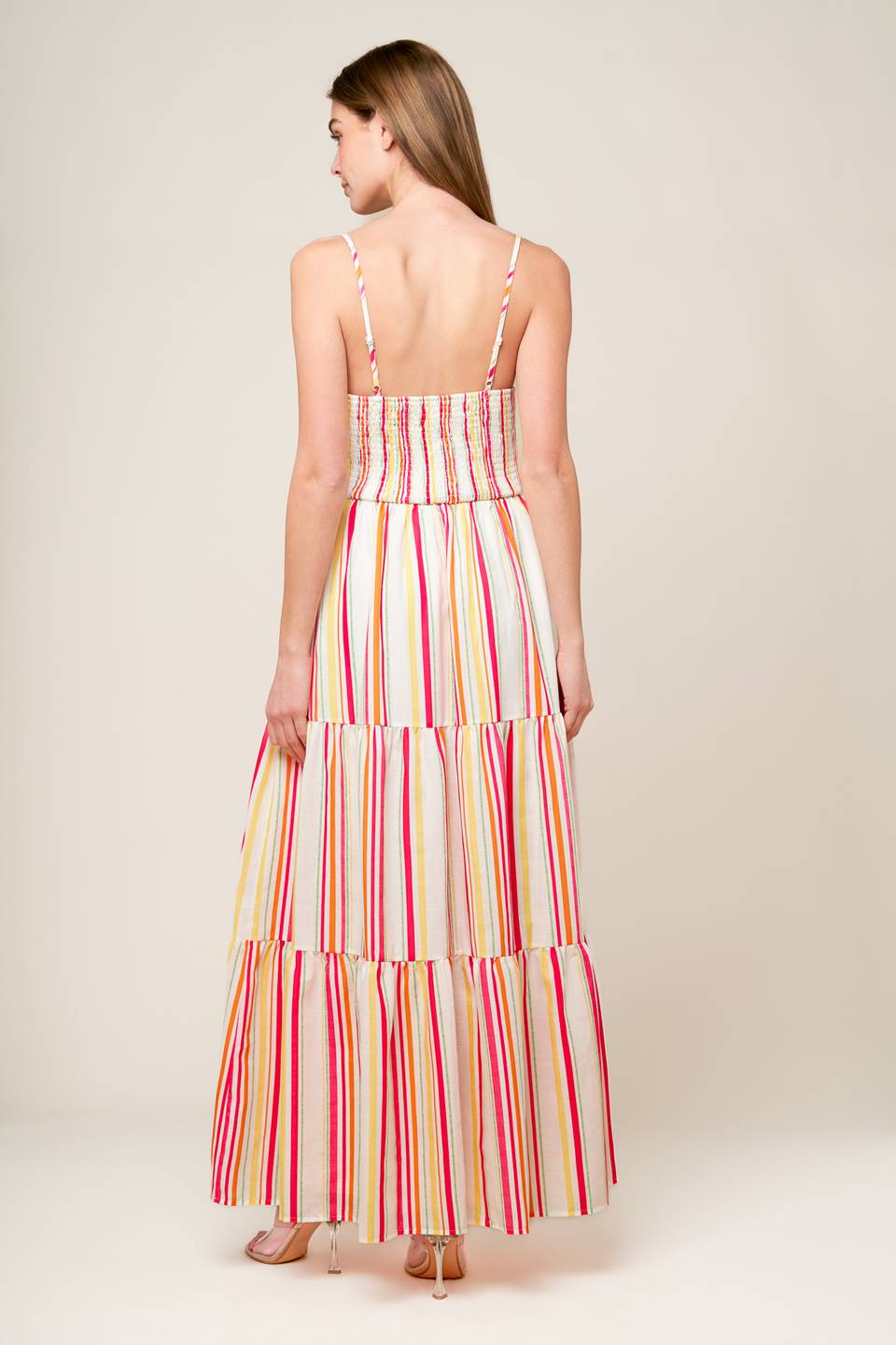 A striped woven maxi dress featuring cami bodice with center front tie and cut out, wide waistband, tiered skirt and smocked back bodice.