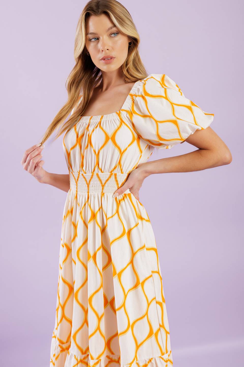 A printed woven midi dress featuring square neckline, short puff sleeves, smocked waistband, full skirt and ruffled hemline