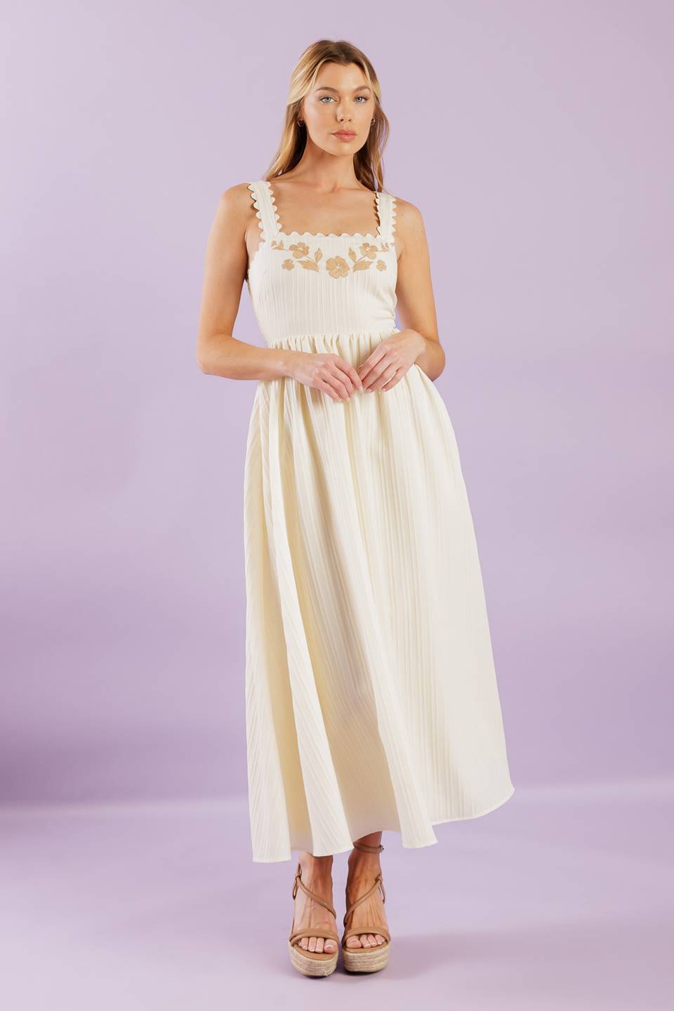 A solid woven midi dress featuring ric rac trimmed straight neckline and straps, embroidered bodice and smocked back bodice.