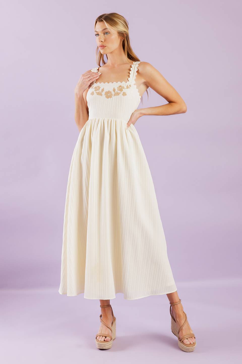 A solid woven midi dress featuring ric rac trimmed straight neckline and straps, embroidered bodice and smocked back bodice.