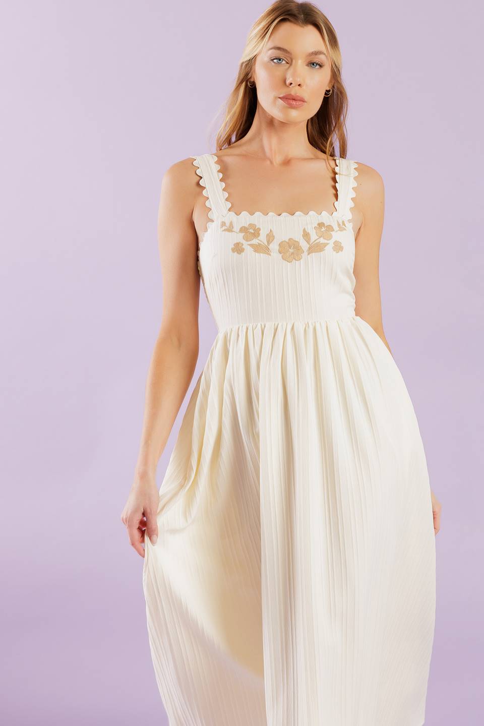 A solid woven midi dress featuring ric rac trimmed straight neckline and straps, embroidered bodice and smocked back bodice.