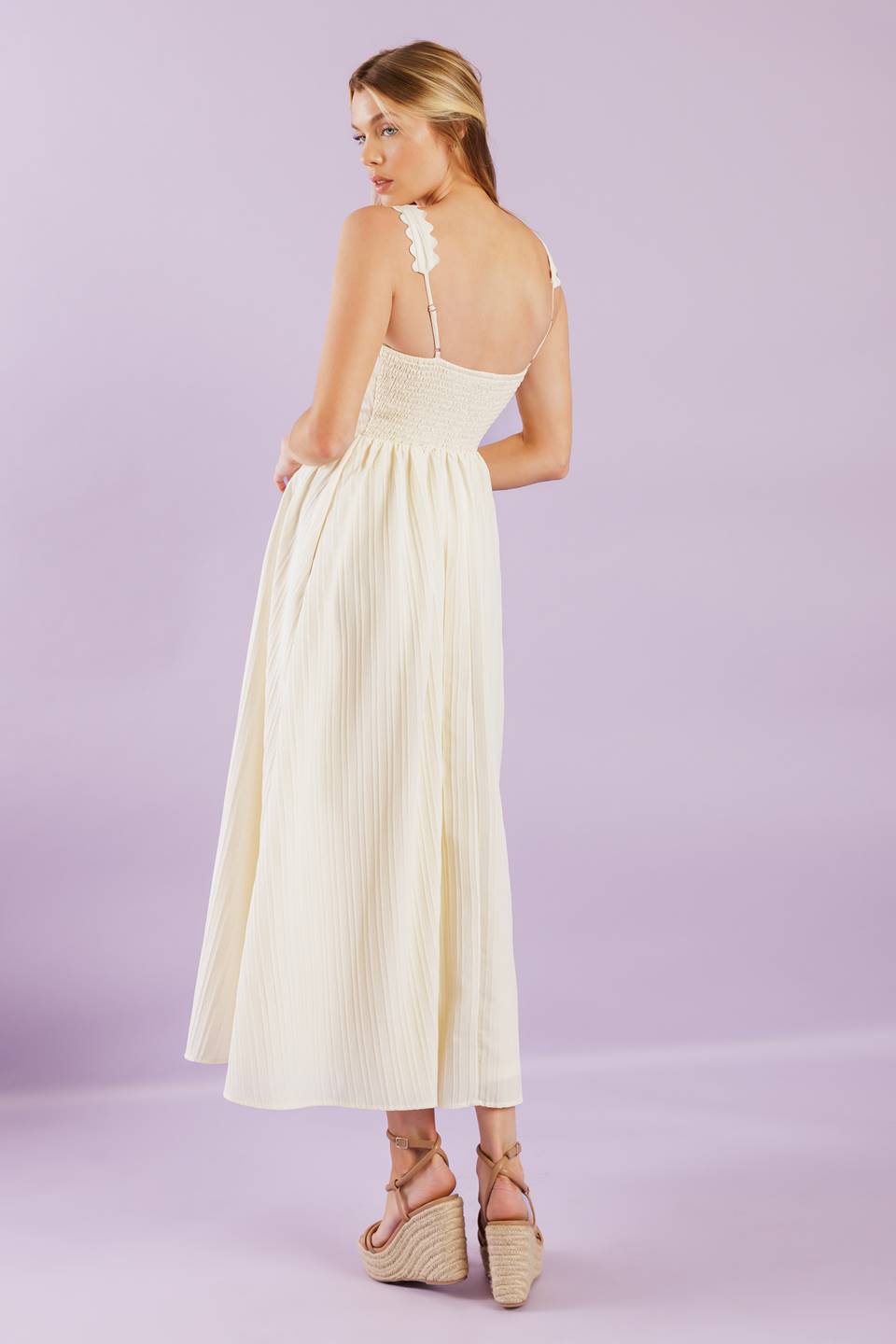 A solid woven midi dress featuring ric rac trimmed straight neckline and straps, embroidered bodice and smocked back bodice.