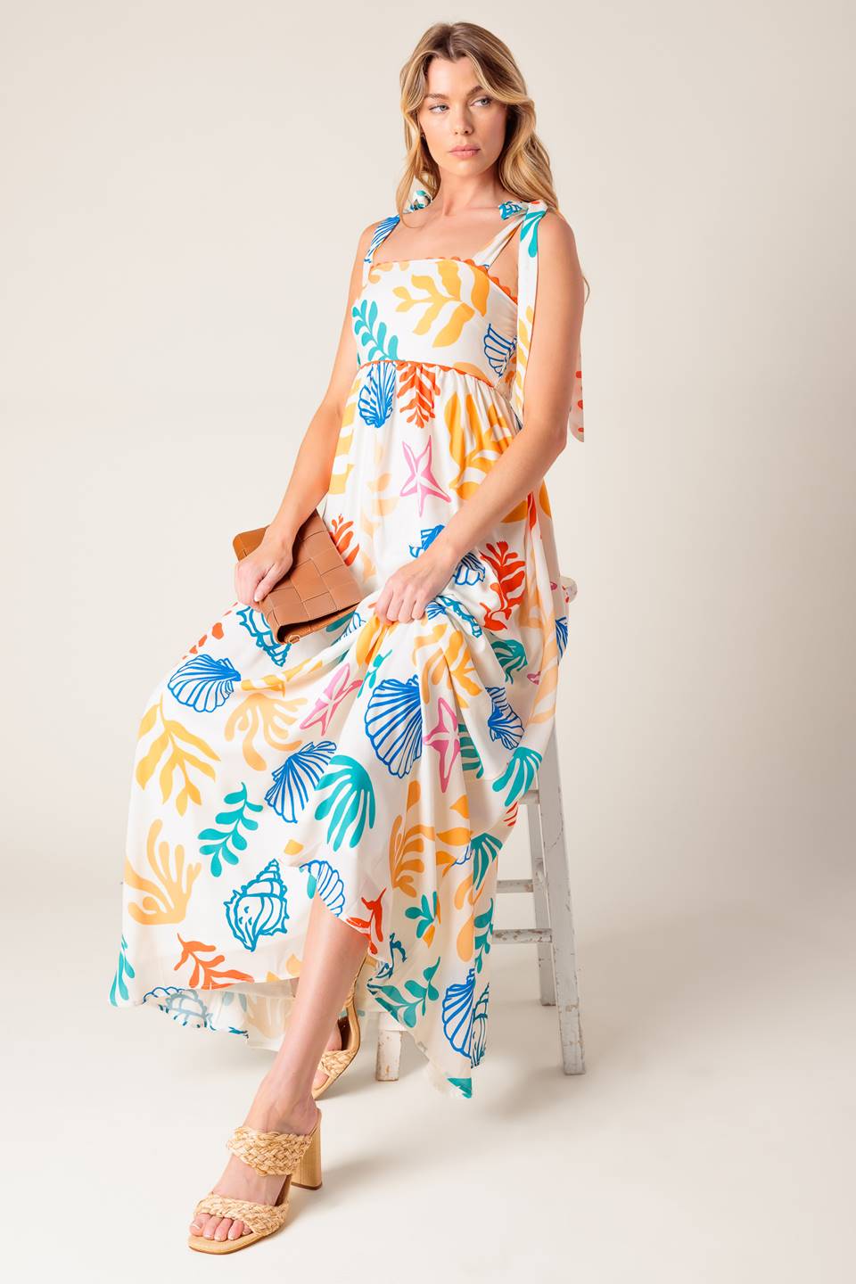 A printed woven maxi dress featuring straight neckline with ribbon edge, shoulder ties and smocked back bodice.