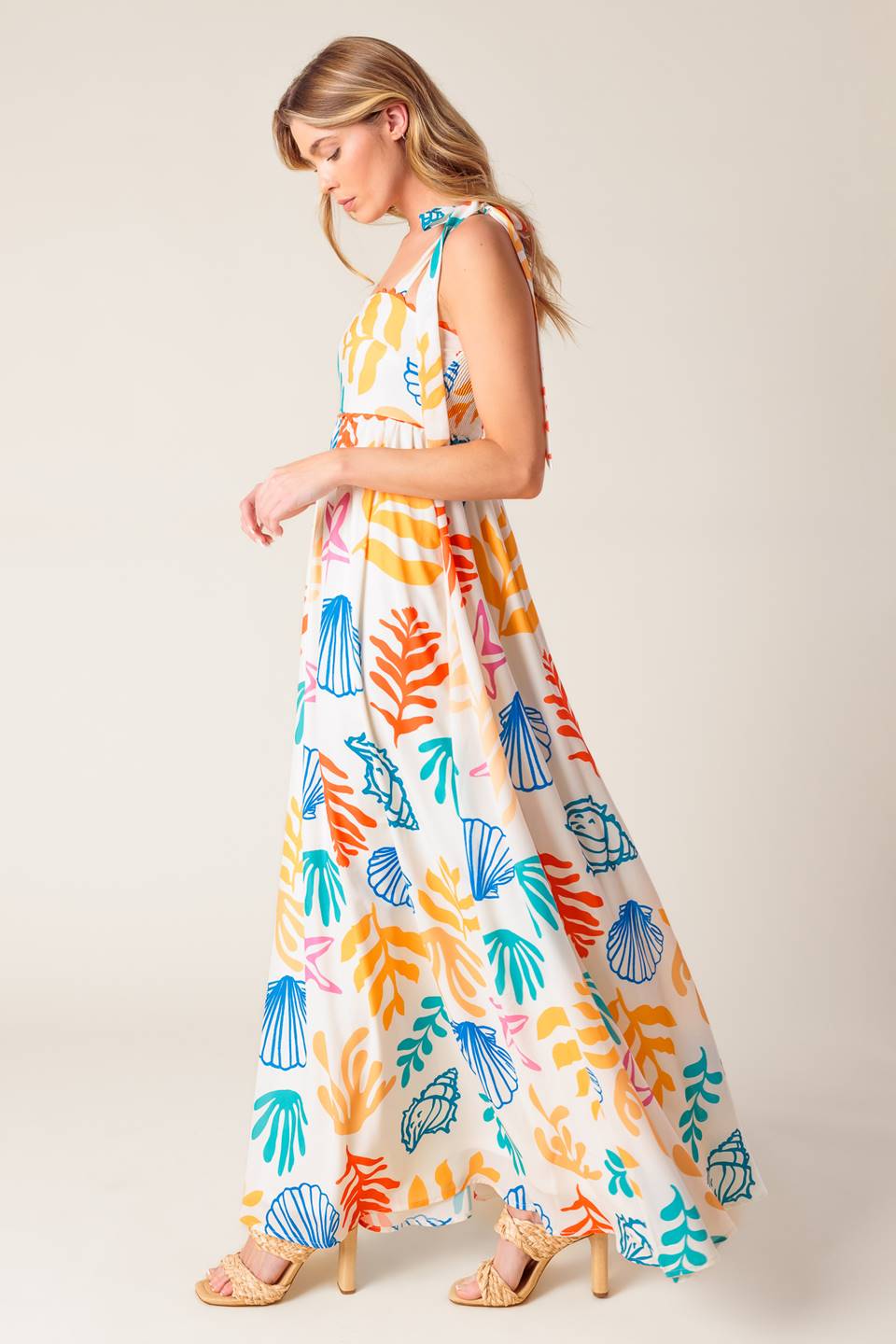 A printed woven maxi dress featuring straight neckline with ribbon edge, shoulder ties and smocked back bodice.