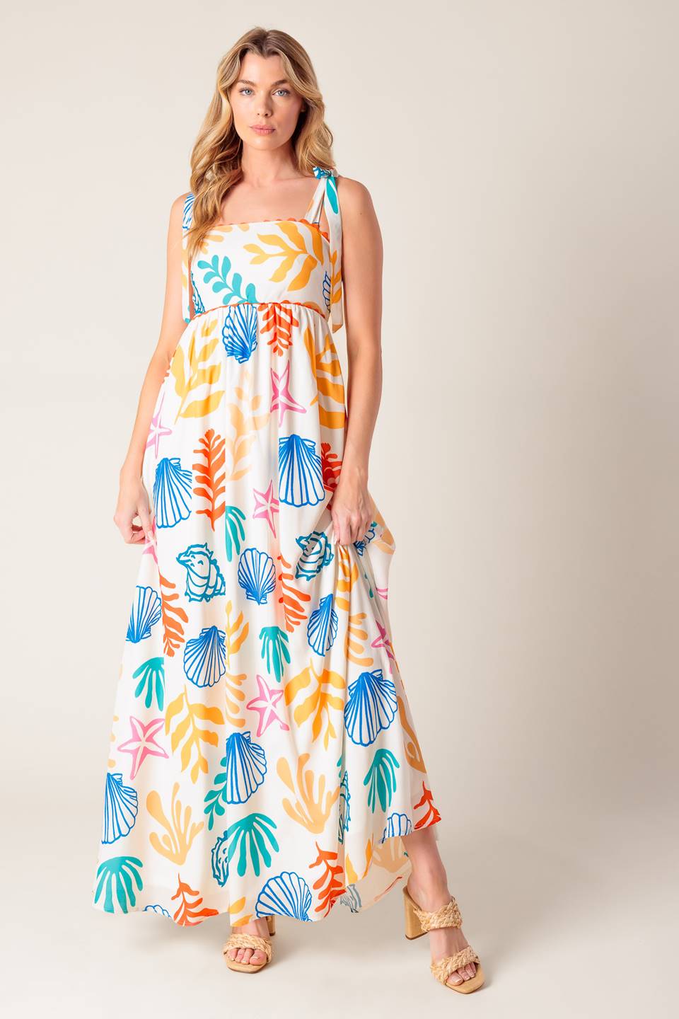 A printed woven maxi dress featuring straight neckline with ribbon edge, shoulder ties and smocked back bodice.