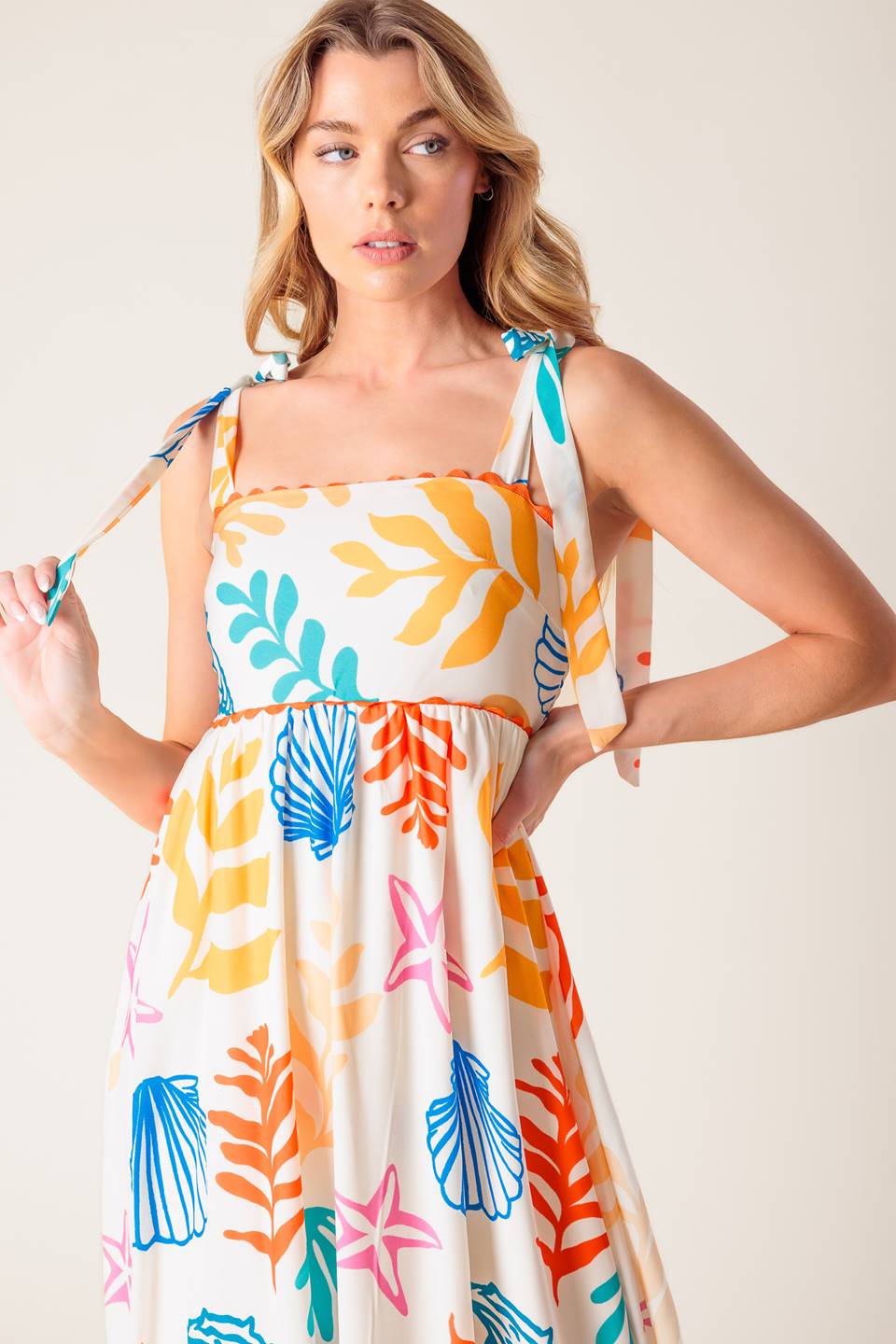 A printed woven maxi dress featuring straight neckline with ribbon edge, shoulder ties and smocked back bodice.