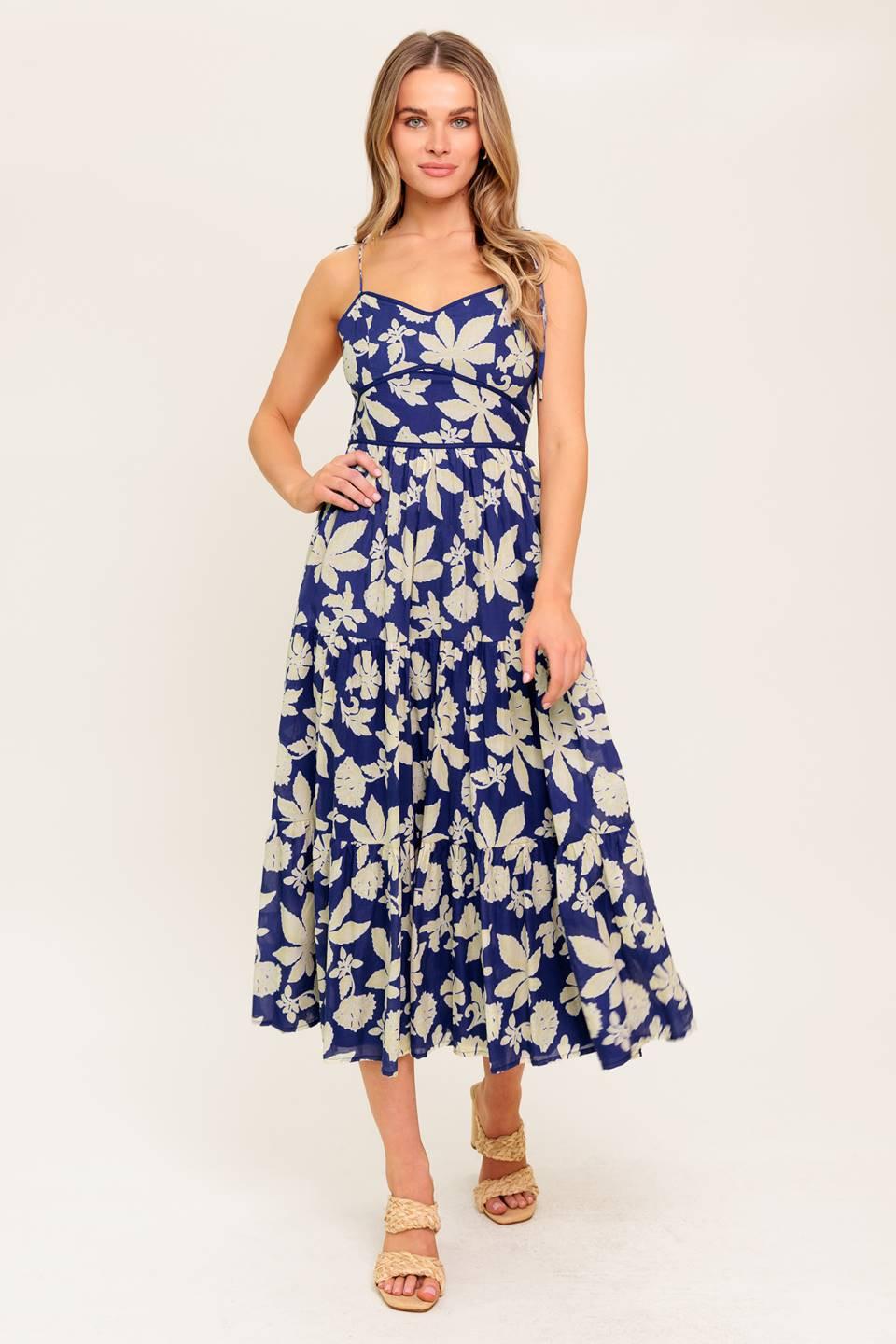 A printed woven midi dress featuring sweetheart neckline, shoulder tie, waist yoke, tiered skirt and back zipper closure.