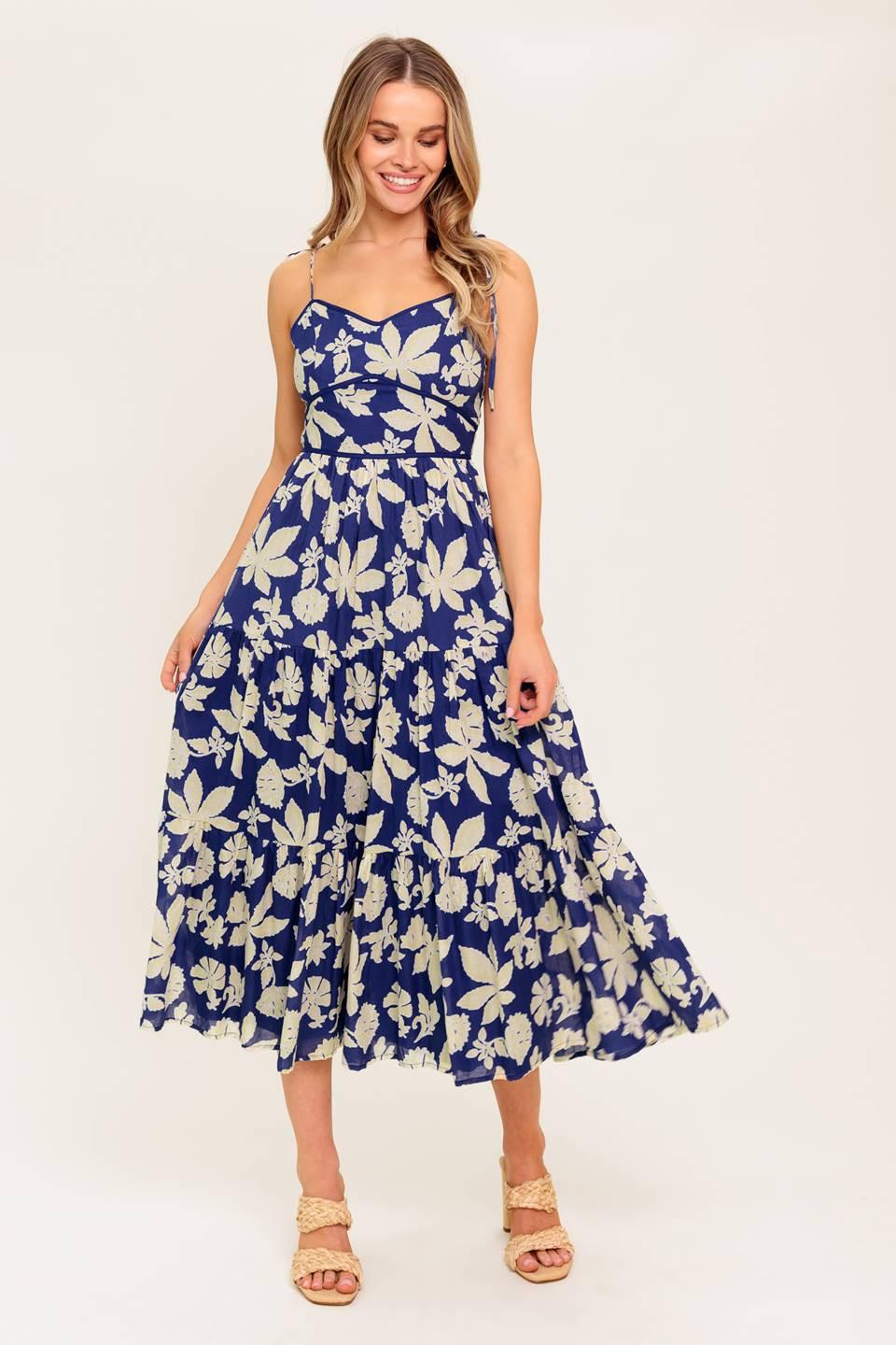 A printed woven midi dress featuring sweetheart neckline, shoulder tie, waist yoke, tiered skirt and back zipper closure.