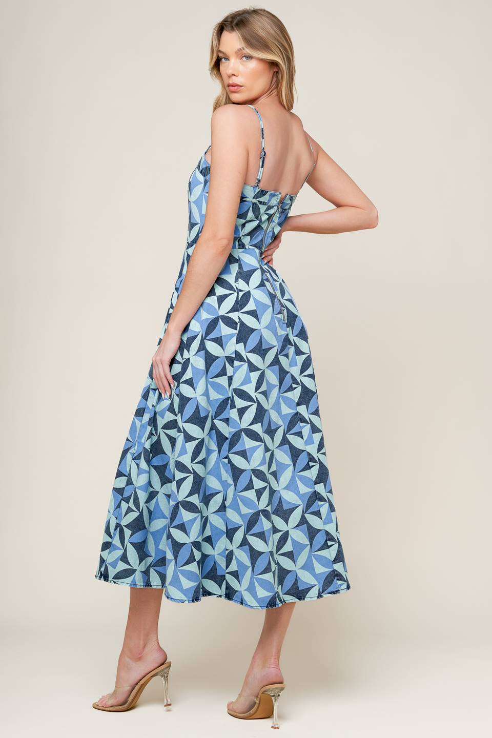 A printed denim midi dress featuring straight neckline, straps, full skirt and back zipper closure.