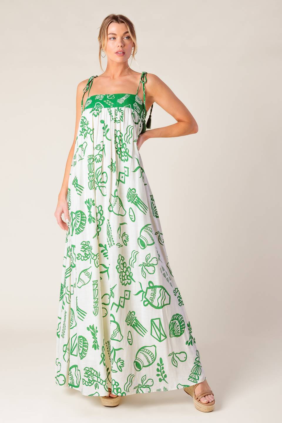 A printed woven maxi dress featuring straight neckline, shoulder tie with tassel and smocked back band