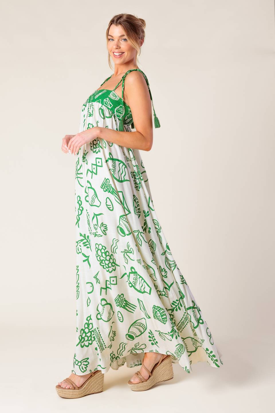 A printed woven maxi dress featuring straight neckline, shoulder tie with tassel and smocked back band