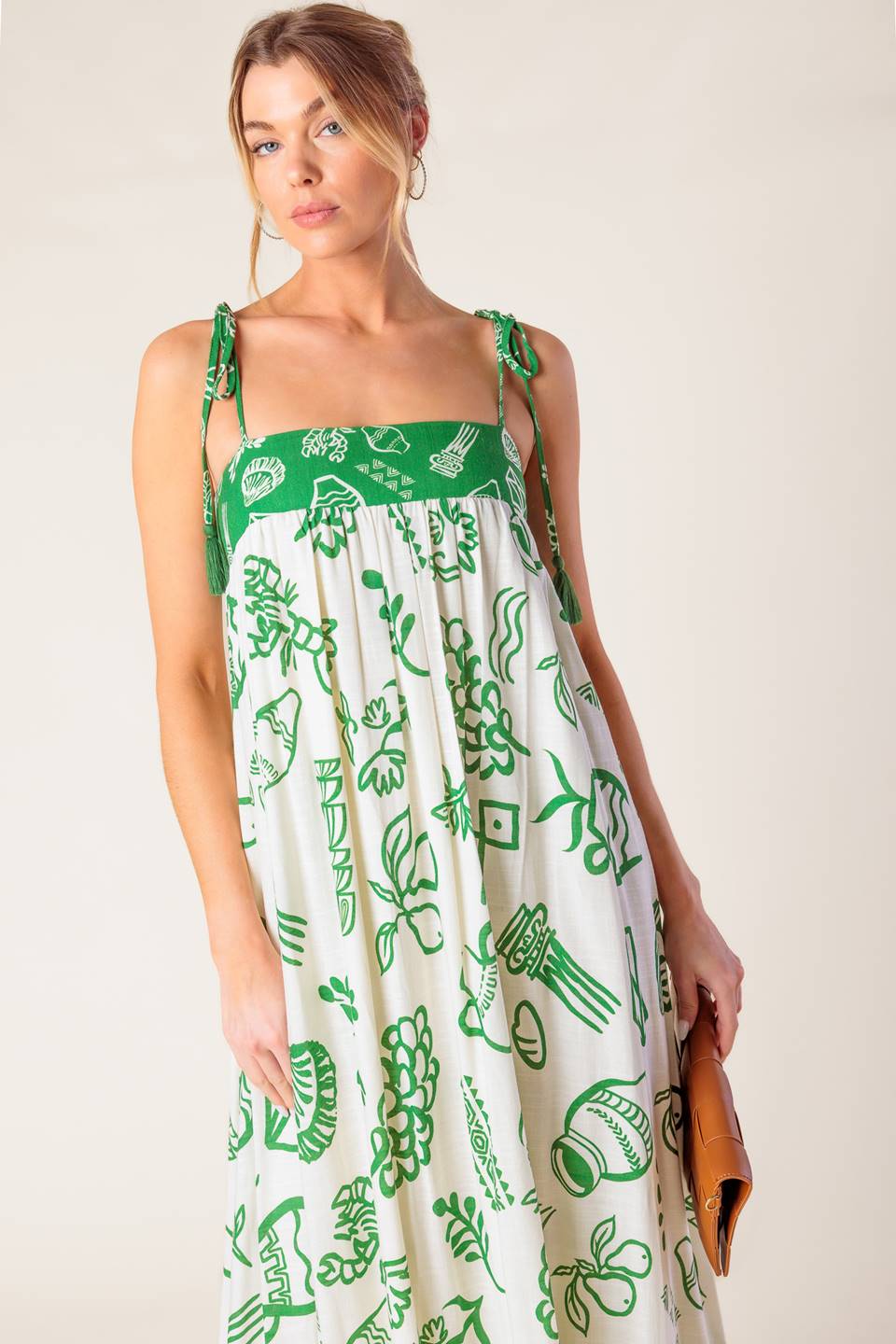 A printed woven maxi dress featuring straight neckline, shoulder tie with tassel and smocked back band