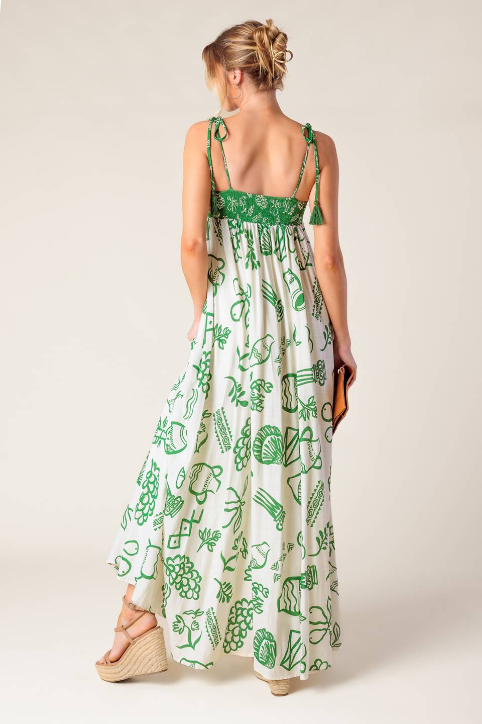 A printed woven maxi dress featuring straight neckline, shoulder tie with tassel and smocked back band