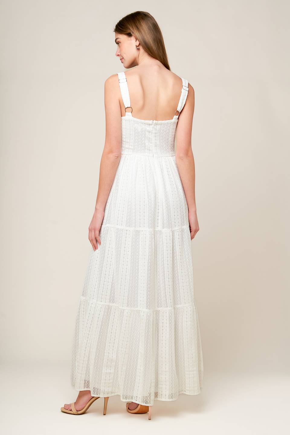 A white woven lace maxi dress featuring straight neckline, straps, tiered skirt and back zipper closure.