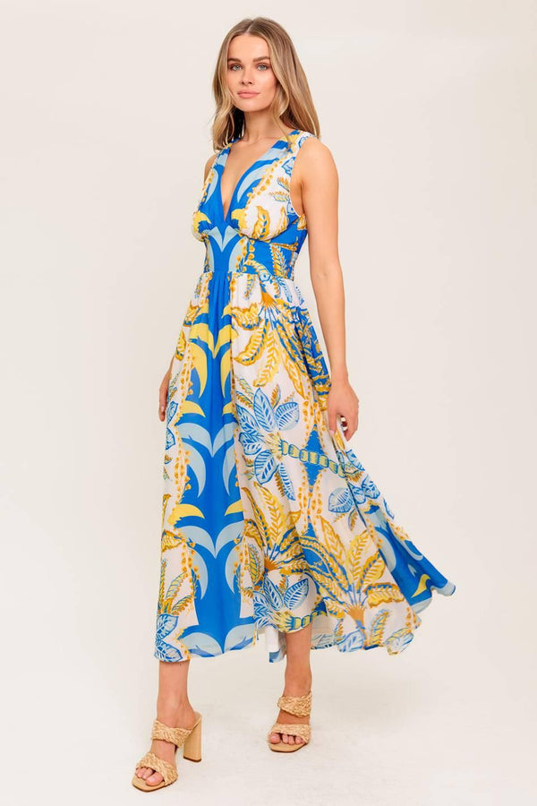 A printed woven midi dress featuring V neckline, sleeveless, waist yoke, full skirt and smocked back waistband.