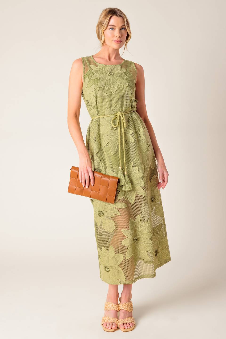 A sage green woven lace midi dress featuring round neckline, sleeveless, braided belt with tassel, cami and back button closure.