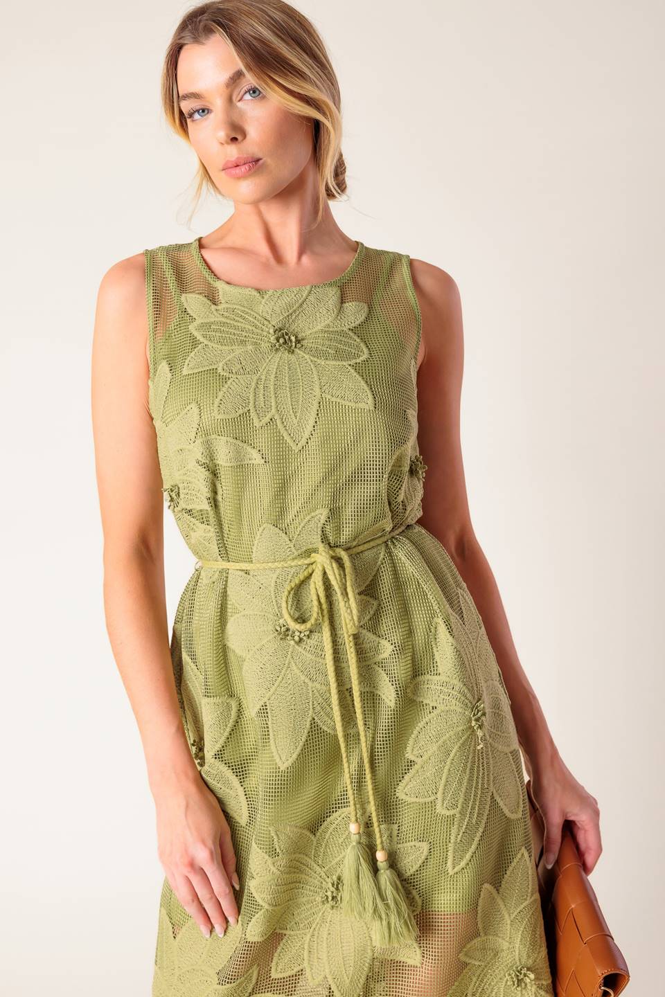 A sage green woven lace midi dress featuring round neckline, sleeveless, braided belt with tassel, cami and back button closure.