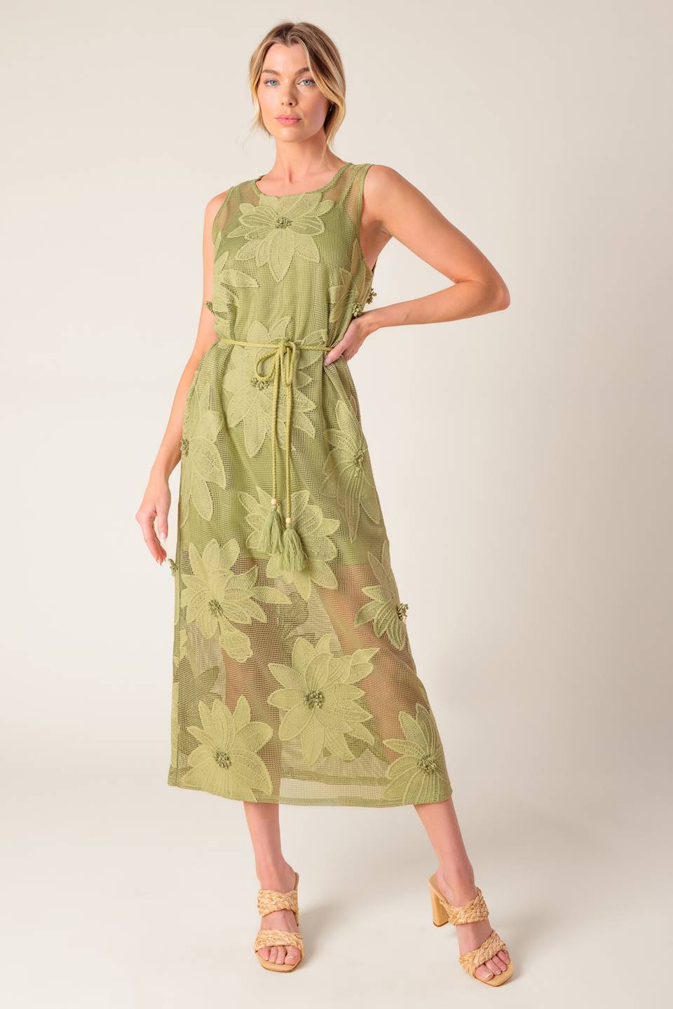 A sage green woven lace midi dress featuring round neckline, sleeveless, braided belt with tassel, cami and back button closure.