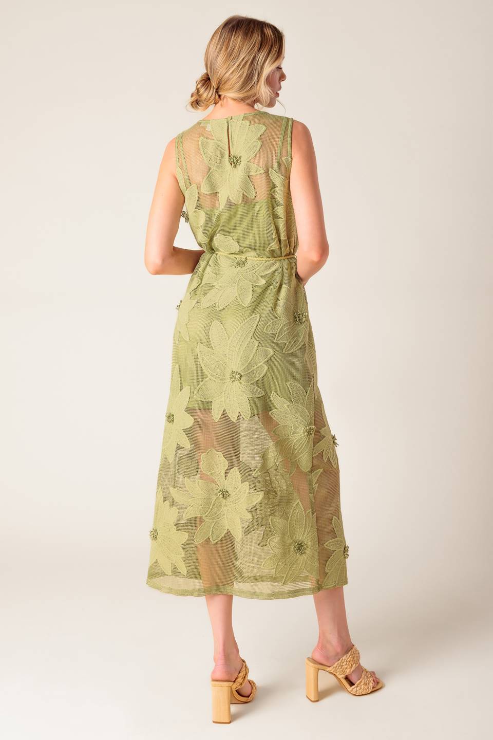 A sage green woven lace midi dress featuring round neckline, sleeveless, braided belt with tassel, cami and back button closure.