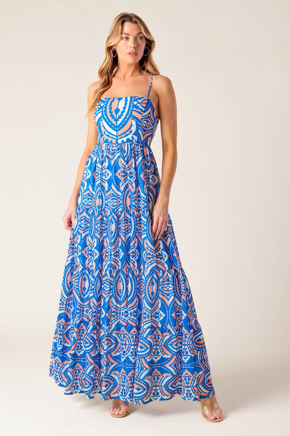 A printed woven maxi dress featuring straight neckline, straps, tiered skirt and smocked back bodice