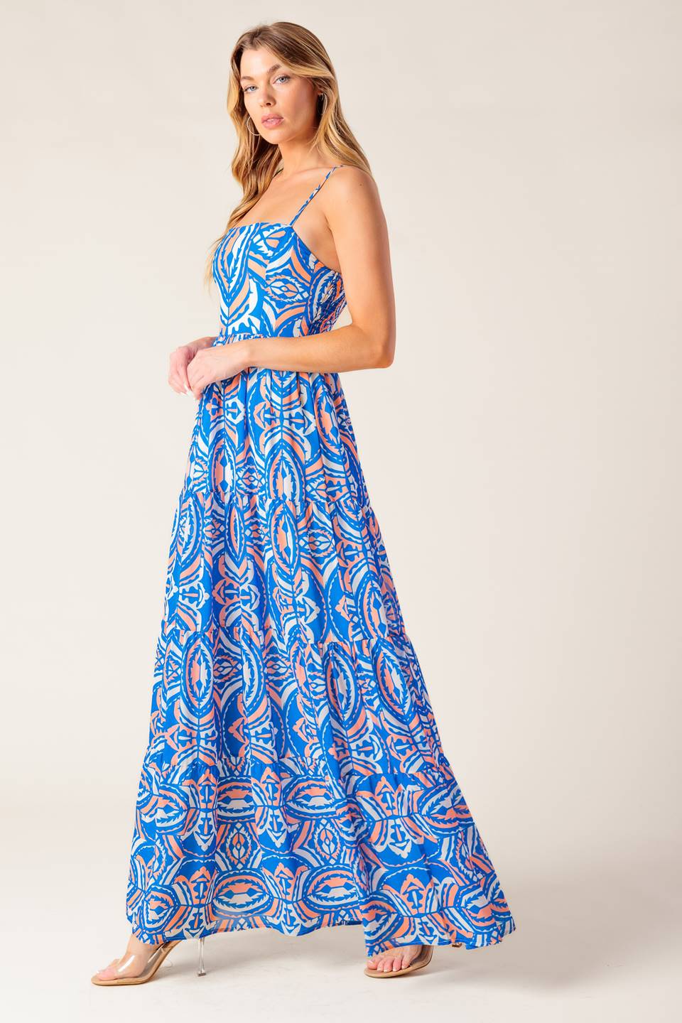 A printed woven maxi dress featuring straight neckline, straps, tiered skirt and smocked back bodice