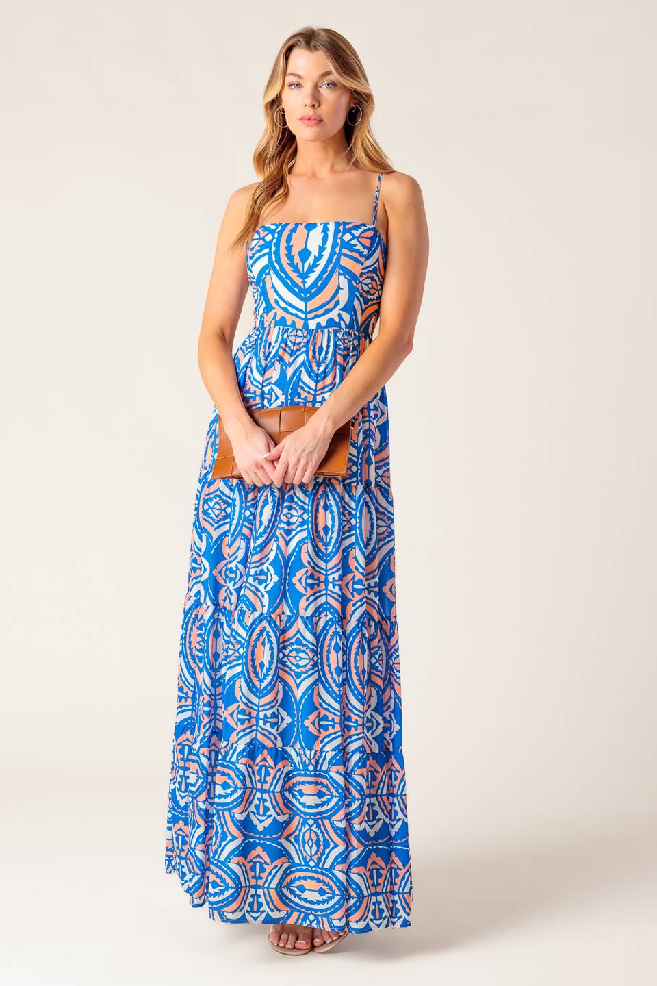 A printed woven maxi dress featuring straight neckline, straps, tiered skirt and smocked back bodice