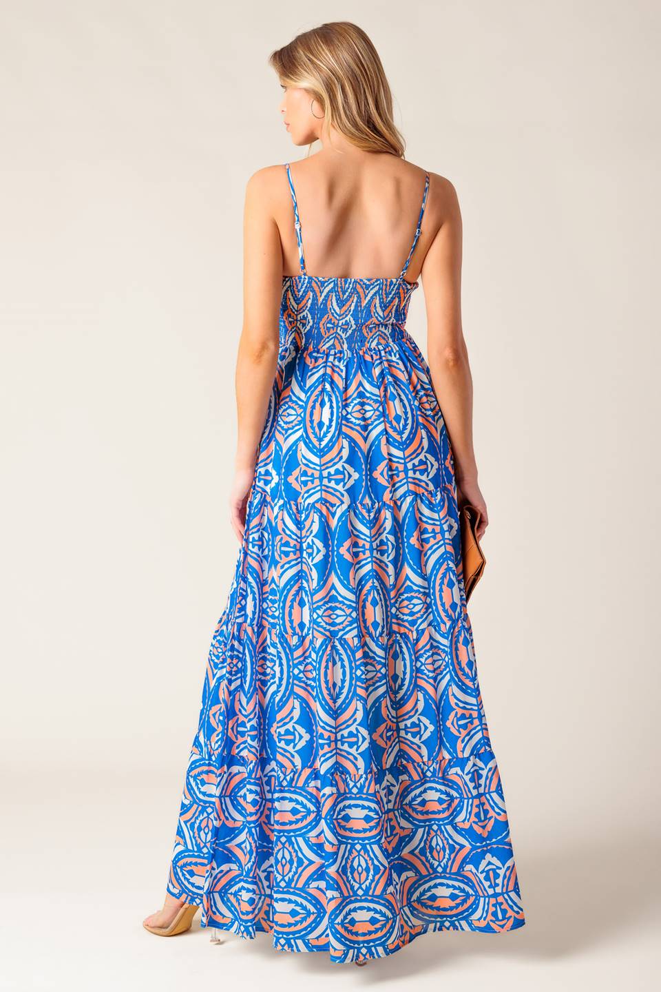 A printed woven maxi dress featuring straight neckline, straps, tiered skirt and smocked back bodice