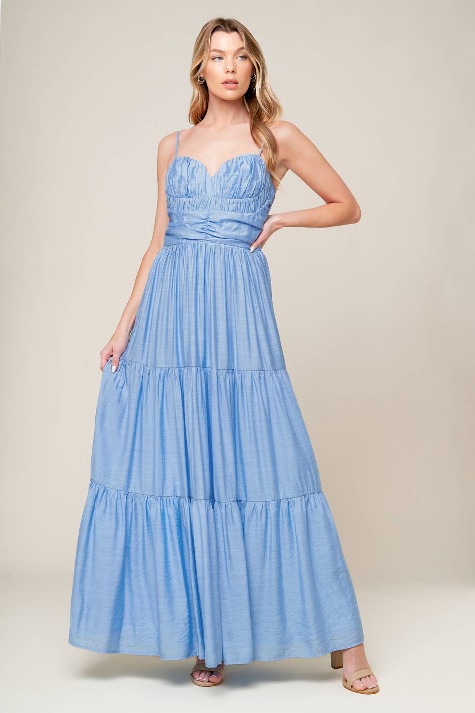 A light blue solid woven maxi dress featuring sweetheart neckline with straps, ruched bodice, tiered skirt and back zipper closure.