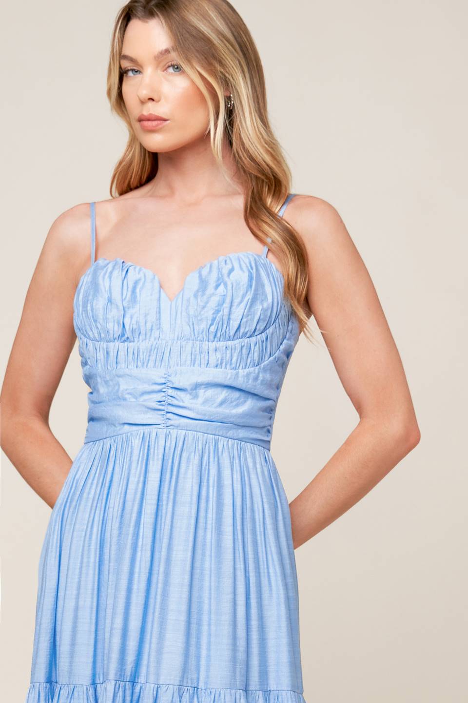 A light blue solid woven maxi dress featuring sweetheart neckline with straps, ruched bodice, tiered skirt and back zipper closure.