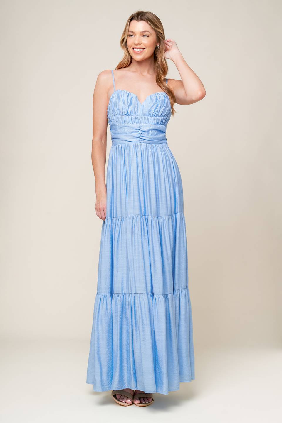 A light blue solid woven maxi dress featuring sweetheart neckline with straps, ruched bodice, tiered skirt and back zipper closure.