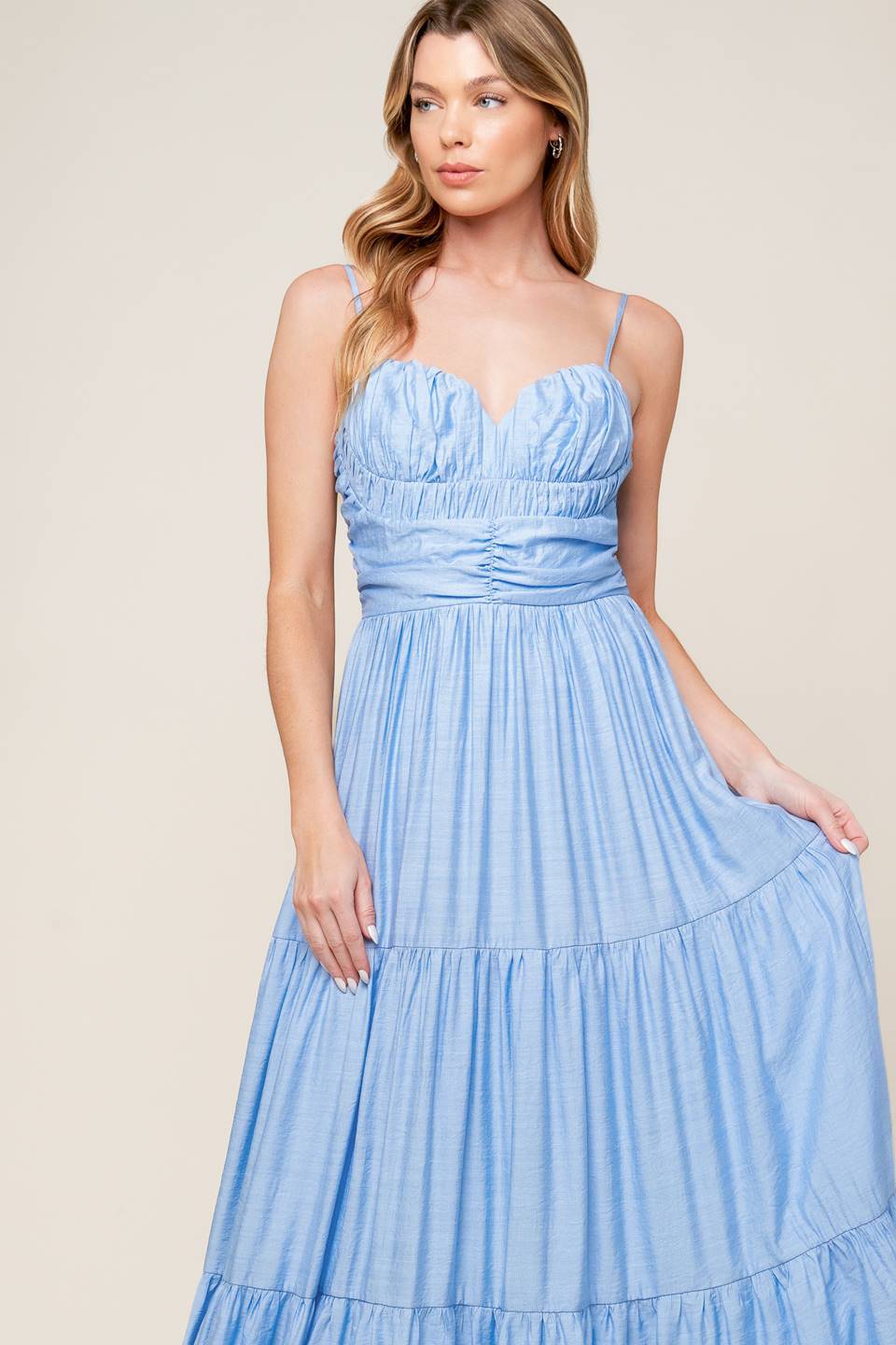 A light blue solid woven maxi dress featuring sweetheart neckline with straps, ruched bodice, tiered skirt and back zipper closure.