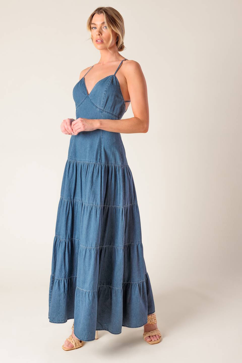 A chambray midi dress featuring cami top, fitted waistline, tiered skirt, bare back with O ring and straps and zipper closure.