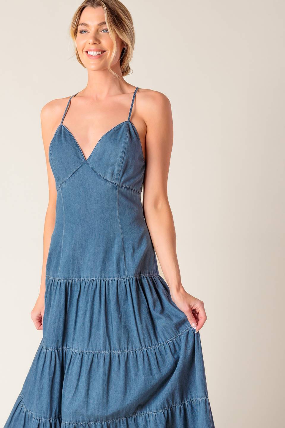 A chambray midi dress featuring cami top, fitted waistline, tiered skirt, bare back with O ring and straps and zipper closure.