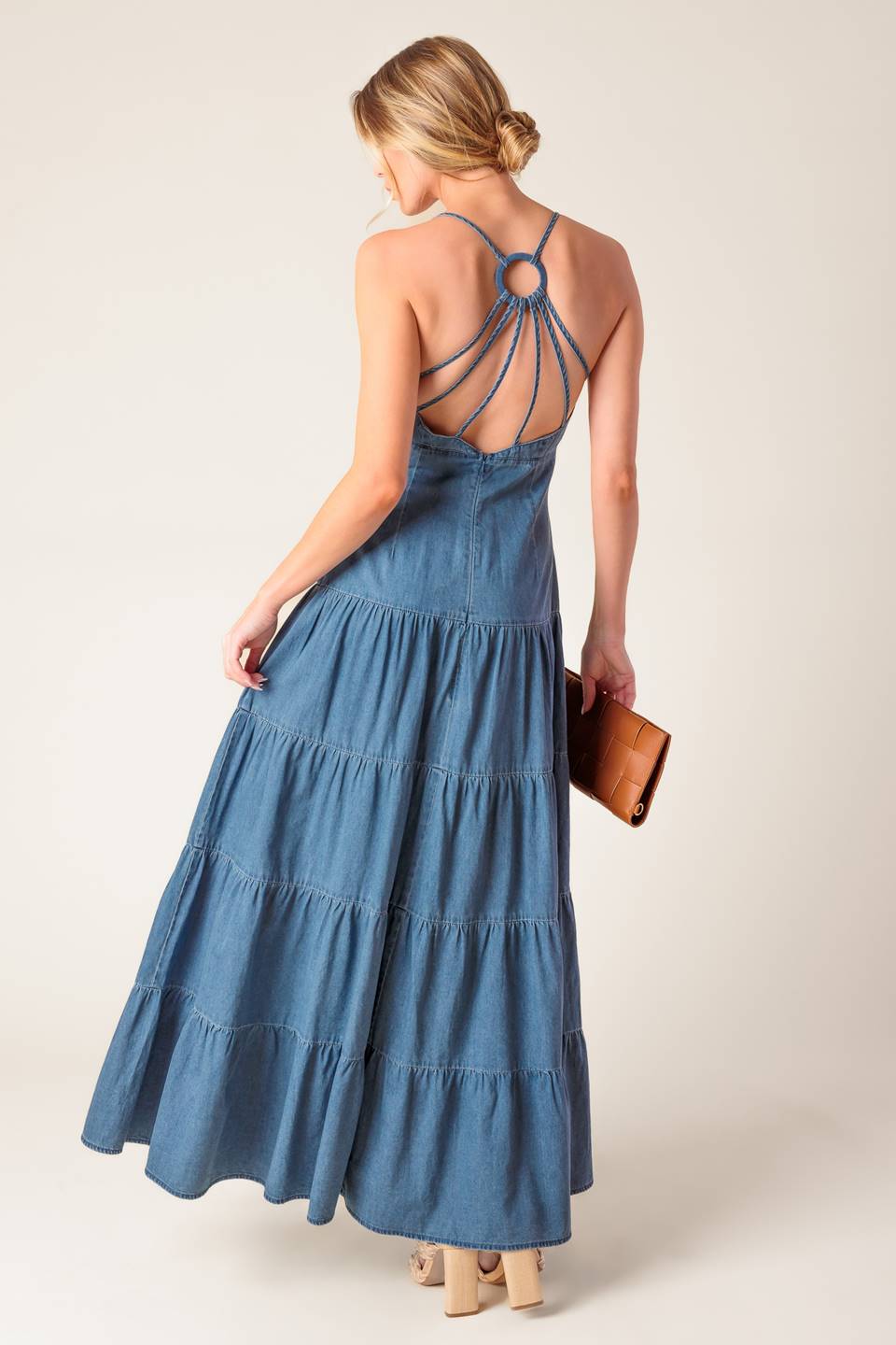 A chambray midi dress featuring cami top, fitted waistline, tiered skirt, bare back with O ring and straps and zipper closure.