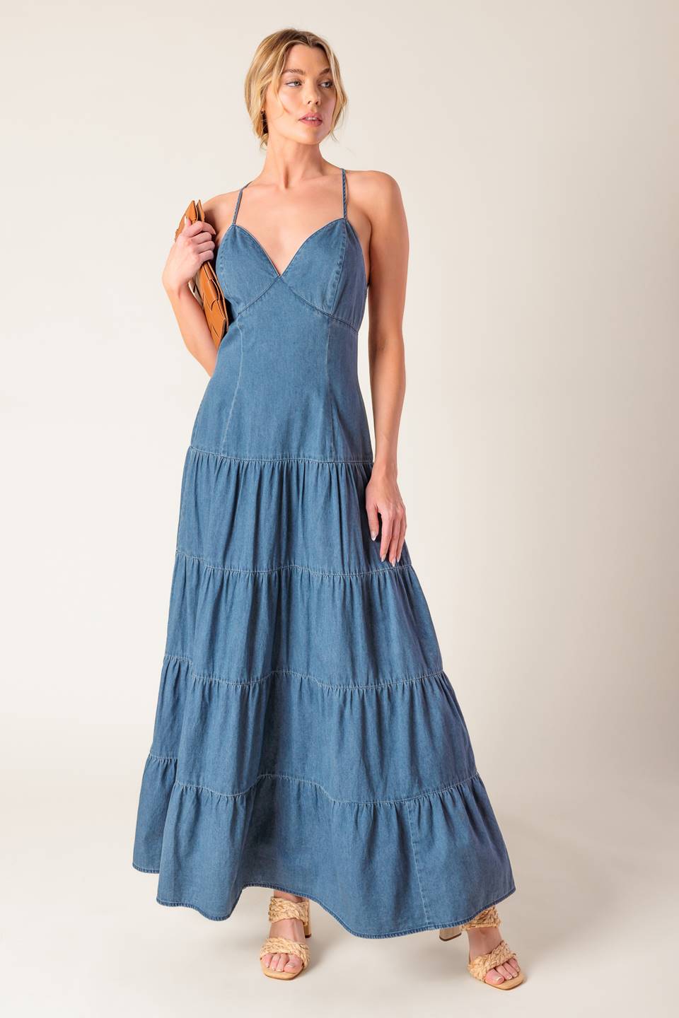 A chambray midi dress featuring cami top, fitted waistline, tiered skirt, bare back with O ring and straps and zipper closure.