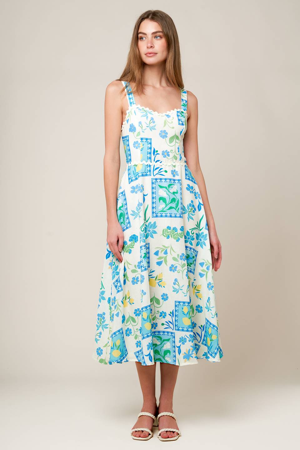 A printed woven midi dress featuring sweetheart neckline with ric rac ribbon trim, straps, full skirt, bare back with tie and zipper closure