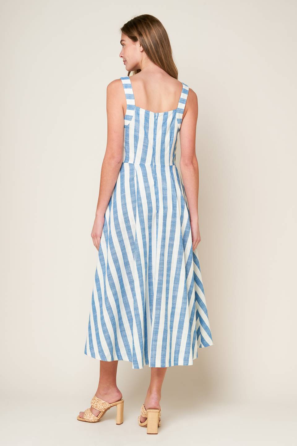 A white and blue striped woven midi dress featuring V neckline, cinched bust center, waist yoke and back zipper closure.